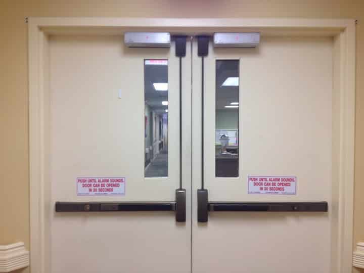 image of a commercial door with panic bars and automatic door closers